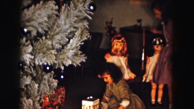 1961: two girls reviewing their gifts at the foot of a christmas tree