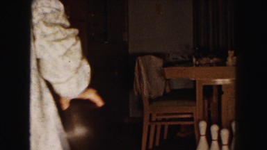 1961: people bowling with a bowling ball and bowling pins inside their home