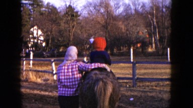 1954: women and children horse riding on a chilly autumn day on a farm