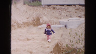 1954: small kid having trouble walking along a red clay embankment HICKSVILLE