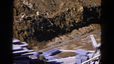 1954: home's cinder block foundation being constructed in neighborhood in autumn