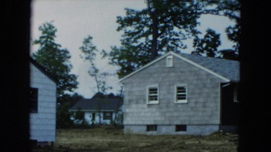 1954: Mid-19th Century Group of Homes in a Forest with a Classic Automobile