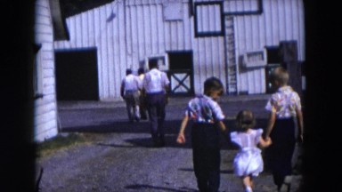 1954: various people walking towards an old tin barn or warehouse HICKSVILLE