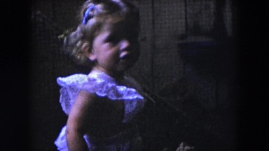 1954: a little blonde girl playing a door and a calf drinking