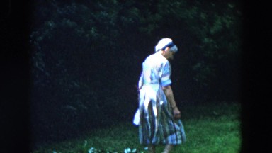 1955: an old woman and a little girl frolicking in a pretty wooded yard
