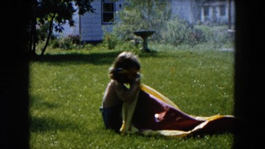 1955: Small Girl Blowing Up Wading Pool Near Bird Bath and Sprinkler in Yard