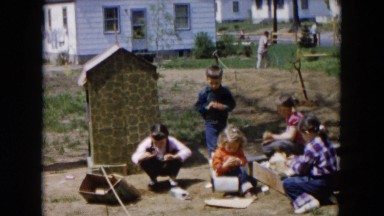 1955: children gathering items and playing near a home with adults
