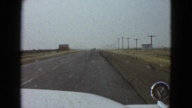 1958: a flat, barren, desolate landscape as seen from a moving vehicle NEVADA