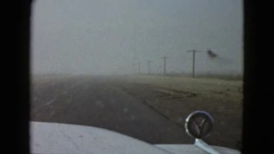 White Car Moving on Highway Through Nevada Desert with Sand Dunes and Truck