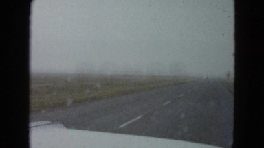 1958: a vehicle is moving through a highway running amid a vast barren land
