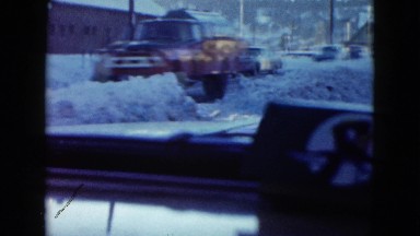 1958: view of a town covered in deep snow in the winter time with cars
