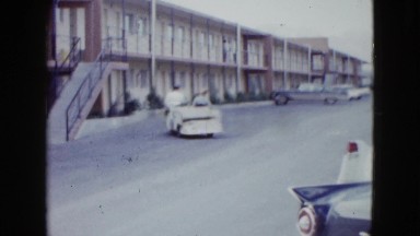 1958: cars passing by waving huge road parked cars NEVADA