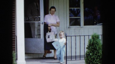 1958: man, woman, and boy walking out the front door of a home