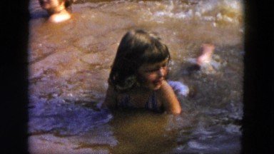 1955: a little girl learning to swim in shallow, muddy water HICKSVILLE