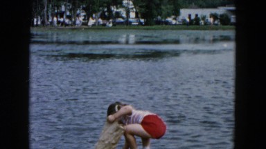 1955: two girls along the shore of a pond, playing in the water HICKSVILLE