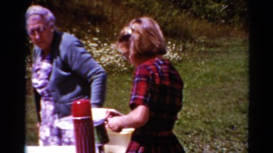1964: Family Enjoying Picnic Lunch on Grass Near Ocean in California