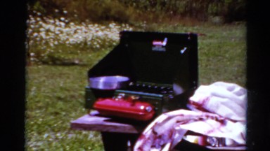 1964: young girl cleans dishes at family cookout CALIFORNIA