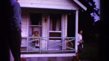 1964: woman leaving a house and a child waves and smiles at the camera