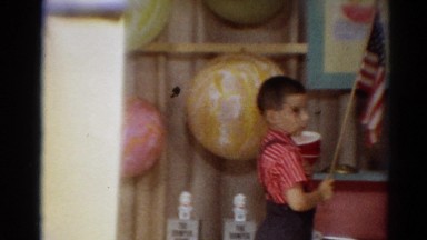 1964: elementary students saying the pledge of allegiance in a classroom