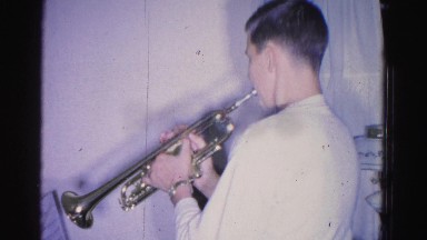 1967: a pair of young practicing amusingly with musical instruments in a room