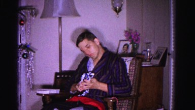 1967: a young man wearing coat sitting in the chair and decorating the christmas