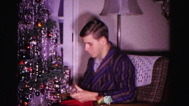 1967: older boy sitting next to christmas tree opening a gift HAGERSTOWN