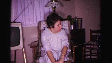 1967: a young girl in a white dress opens a cardboard box HAGERSTOWN, MARYLAND