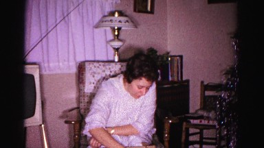 1967: a woman in a chair pulling a case from a box on the floor HAGERSTOWN