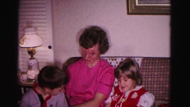 1967: a woman seated on a plaid couch with a cute little girl and boy