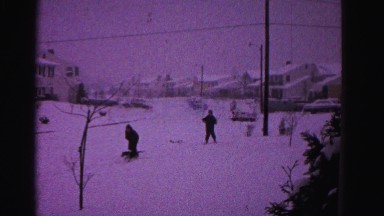 1967: people playing with dog in the snow HAGERSTOWN, MARYLAND