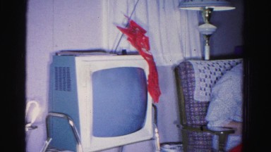 1967: woman opening gift next to christmas tree HAGERSTOWN, MARYLAND