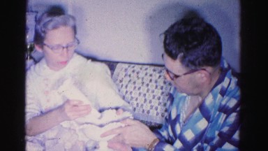 1967: a couple in pajamas on the couch examining an item HAGERSTOWN, MARYLAND