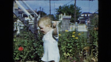1951: A Beautiful Blonde Child Wandering on the Lawn Near a Garden in Cleveland, Ohio