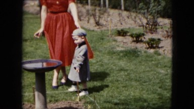 1951: a woman and little boy walking around outdoor on a windy day