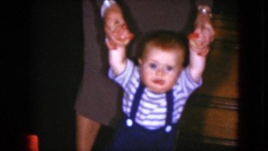 1951: a little baby learning to walk is helped by an adult woman CLEVELAND, OHIO