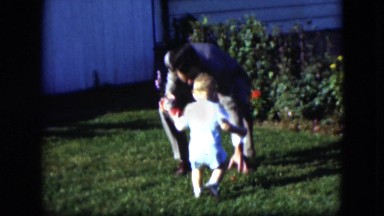 1951: father playing with his son in the garden of his house