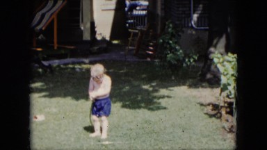 1951: happy boy enjoying water from the water hose in his yard CLEVELAND, OHIO