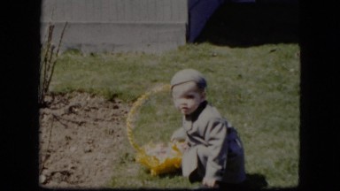 1951: a young boy curiously examining an easter basket CLEVELAND, OHIO