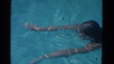 1953: young girl in one piece bathing suit demonstrates the breastroke style