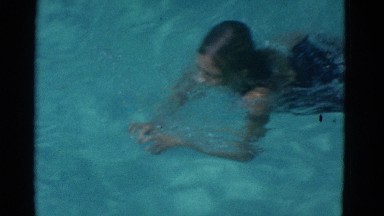1953: young girl wearing dark one piece swimming in blue water NEW YORK