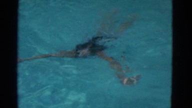 1953: a small girl swimming in the pool, wearing bathing suit
