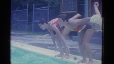 1953: three girls practice diving into blue pool for swim races NEW YORK