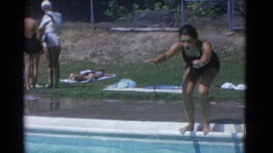 1953: a young woman on a sunny day dives in a pool and swims across it NEW YORK