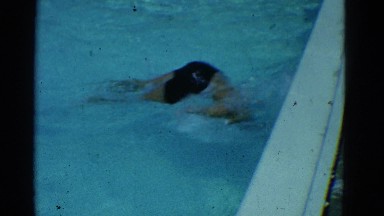 1953: a guy having fun and showing his prowess in the pool to his father