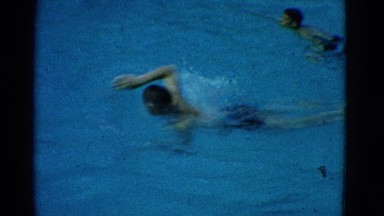 1953: young people are swimming and exercising in a pool using different strokes