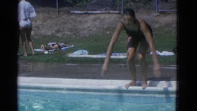 1953: a pretty young woman in a one piece suit diving into a swimming pool