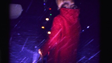 1967: woman in red coat walking dog in coat through snow and christmas
