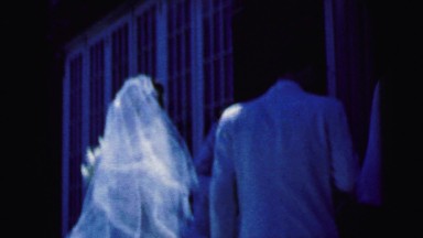 1964: groom ushers bride into building after bridal party enters CAMDEN