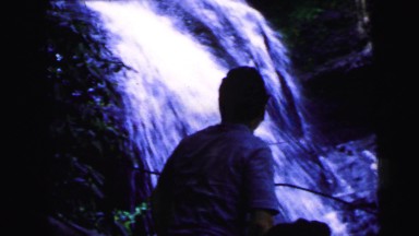1964: a man is exploring the side of a waterfall trail accompanied by two ladies