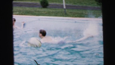 1964: a group of adults enjoying a swimming pool in a sunny day CAMDEN